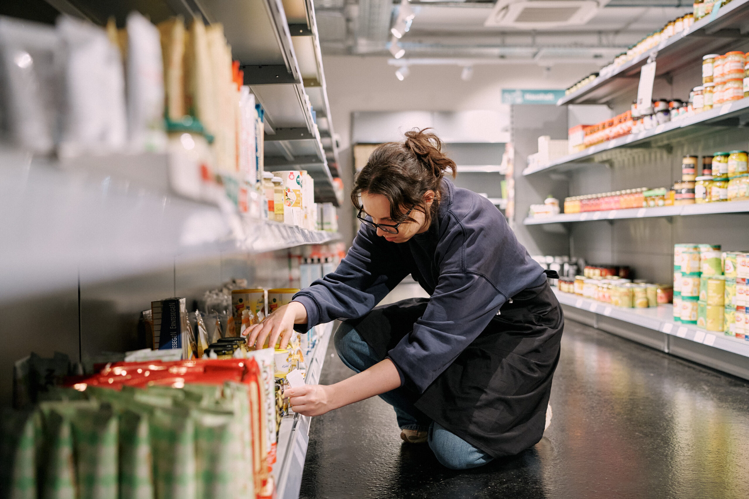MILA Supermarkt Eröffnung_101025_Zoe Opratko_833_web MILA-Mitglieder beim Schlichten von Regalen in einer Mitmach-Schicht.
